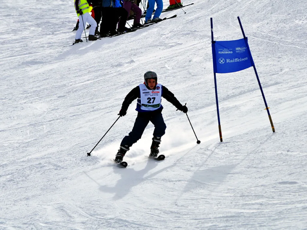 Skifahrer mit Startnummer 27 zwischen den Toren.